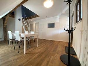 a dining room with a table and chairs and a staircase at Business Apartment ZIMMERzuVERMIETEN in Wangen an der Aare in Wangen an der Aare +3 photos