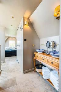 een badkamer met een wastafel en een wastafel met een spiegel bij Luxury private farmhouse cottage near Amsterdam plus home cinema in Ilpendam