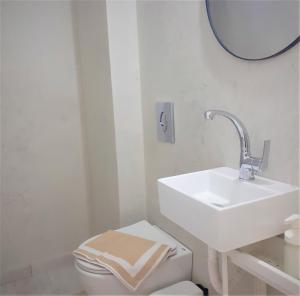 ein Badezimmer mit einem Waschbecken, einem WC und einem Spiegel in der Unterkunft Kineta Seaside Summer Apartments in Kineta