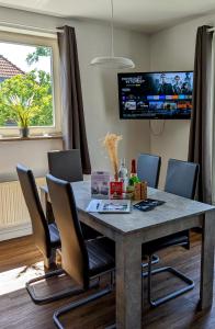 a dining room table with chairs and a tv on the wall at Leipzig-Residenz Waldstraße am Zoo und Red Bull Arena , Rooftop Apartment mit 2 Dachterrassen in Leipzig