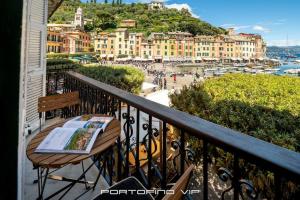 einen Tisch auf einem Balkon mit Stadtblick in der Unterkunft Portofino Luxury Front Marina by PortofinoVip in Portofino