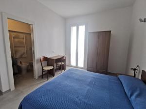 a bedroom with a blue bed and a table and chairs at Affittacamere Montecarlo in Laigueglia