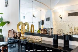 a dressing room with gold mirrors and a black counter at Portofino Luxury Front Marina by PortofinoVip in Portofino +27 photos