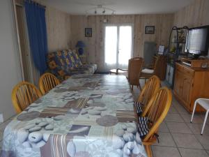 een eetkamer met een tafel met stoelen en een woonkamer bij Maison Grues, 3 pièces, 5 personnes - FR-1-476-31 in Grues