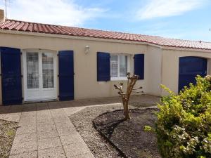een huis met blauwe deuren en een boom op de oprit bij Maison Grues, 3 pièces, 5 personnes - FR-1-476-31 in Grues