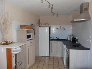 uma cozinha com electrodomésticos brancos e um frigorífico branco em Maison L'Aiguillon-sur-Mer, 3 pièces, 5 personnes - FR-1-476-42 em LʼAiguillon-sur-Mer