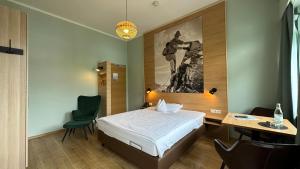 a bedroom with a bed and a table and a chair at Alpenstadthotels in Bad Reichenhall