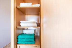 a closet with green towels and white towels at Clube Praia Mar Flat T1 in Portimão