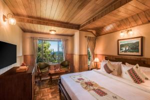 een hotelkamer met een bed en een televisie bij Willow Hill by Nature Resorts in Ooty