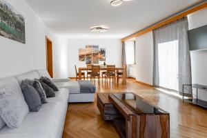 sala de estar con sofá blanco y mesa en Casa Bernina, en Poschiavo