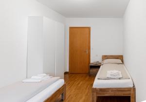 a room with two beds and a wooden door at Casa Bernina in Poschiavo