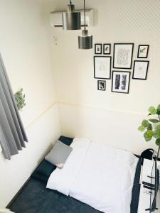 a bed in a room with pictures on the wall at Alo BnB 4 - Near SHINJUKU, SHINOKUBO - Self check-in in Tokyo