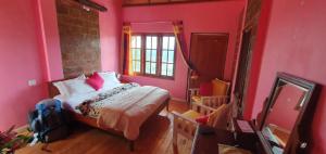 una camera da letto con pareti rosa, letto e specchio di Sincere Wilderness Home stay a Nuwara Eliya