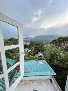 una finestra con vista su una casa con tetto blu di Sincere Wilderness Home stay a Nuwara Eliya
