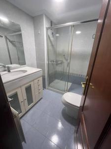 een badkamer met een douche, een toilet en een wastafel bij Piso en Vigo con vistas a la ría in Vigo