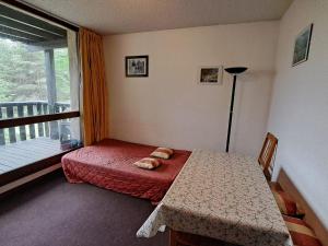 Appartement Pra-Loup, 2 pièces, 4 personnes - FR-1-165A-85 في Uvernet: غرفة نوم صغيرة مع سرير وشرفة