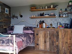a bedroom with a bed and a wooden cabinet at Rhubarb Hut, set in the beautiful Cornish Countryside in Helston