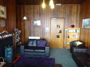 a living room with a couch and a book shelf at Gairloch Sands Youth Hostel in Gairloch