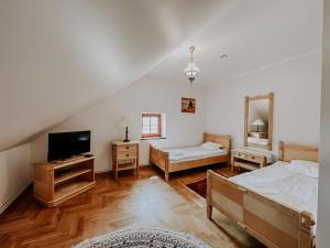 a large room with two beds and a television at Dwór Mościbrody in Siedlce