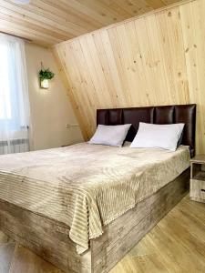 a bedroom with a large bed with a wooden ceiling at Wood Rest Tsaghkadzor in Tsaghkadzor