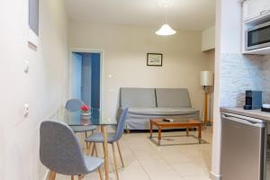 a living room with a couch and a table and chairs at Aspa Holidays in Kos Town