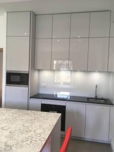 Una cocina con gabinetes blancos y encimera. en Ma terrasse sur le musée, en Chambéry 12 fotos más