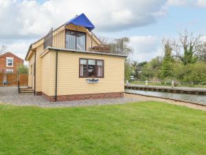 a house with a balcony on top of a yard at Solace Lodge in Norwich