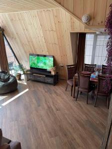 a living room with a tv and a table with chairs at Wood Rest Tsaghkadzor in Tsaghkadzor