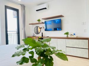 1 dormitorio con espejo y TV en la pared en Amanda Boutique -Serviced Apartment - Hotel Bình Dương en Thu Dau Mot