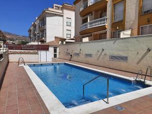 una piscina frente a un edificio en Apartamento playero con vistas a la montaña, en Castell de Ferro