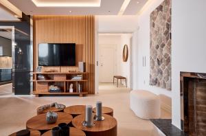a living room with a fireplace and a tv at Elaia Luxury Selections Opal in Athens