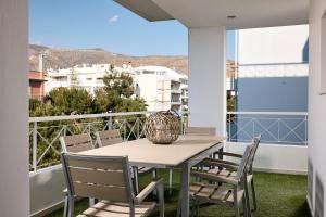 a table and chairs on a balcony with a view at Elaia Luxury Selections Opal in Athens