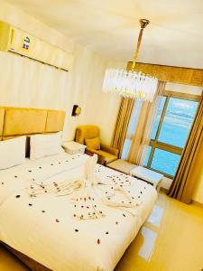 sypialnia z dużym białym łóżkiem z żyrandolem w obiekcie شاليهات ويف -Wave Resort w mieście Al-Chubar