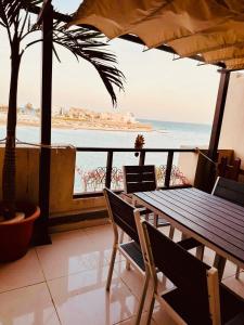 stół i krzesła z widokiem na ocean w obiekcie شاليهات ويف -Wave Resort w mieście Al-Chubar
