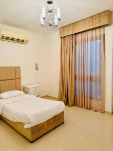 ein Schlafzimmer mit einem Bett und einem großen Fenster in der Unterkunft شاليهات ويف -Wave Resort in Khobar