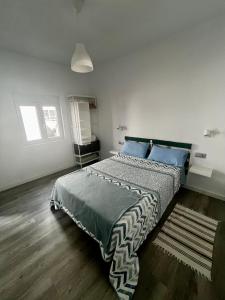1 dormitorio con 1 cama grande con almohadas azules en Casa Rosaura, en La Santa