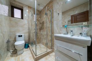 a bathroom with a shower and a toilet and a sink at Aurora Villas in Dilijan