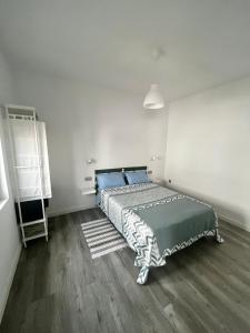1 dormitorio con 1 cama con almohadas azules en Casa Rosaura, en La Santa