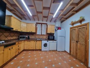 a kitchen with wooden cabinets and a washer and dryer at Villa Majorera para 13 Huéspedes y piscina privada in Villaverde