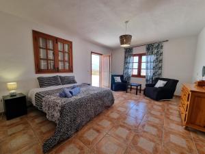 a bedroom with a bed and two chairs in it at Villa Majorera para 13 Huéspedes y piscina privada in Villaverde +65 photos