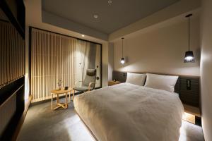 a bedroom with a large white bed and a chair at Hotel Resol Trinity Osaka in Osaka