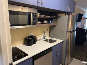 una pequeña cocina con fregadero y microondas en MainStay Suites Ozona I-10, en Ozona