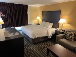 a hotel room with a bed and a couch at MainStay Suites Ozona I-10 in Ozona