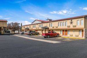 a building with a red truck parked in a parking lot at MainStay Suites Ozona I-10 in Ozona