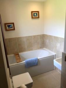 a bathroom with a white tub and a blue towel at Nant-Y-Glyn in Llandrindod Wells