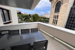 - un balcon avec une table et des chaises dans un bâtiment dans l'établissement Apartment hyper-center Biarritz with parking, à Biarritz