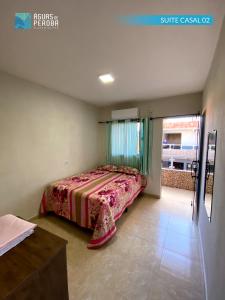 a bedroom with a bed in the corner of a room at Pousada Águas de Peroba Flats e Suites in Maragogi