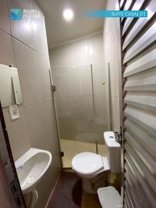 a bathroom with a toilet and a sink and a shower at Pousada Águas de Peroba Flats e Suites in Maragogi