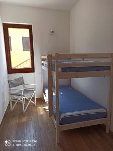 a bedroom with two bunk beds and a window at Il Maestrale in Isola Rossa