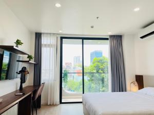 Thu Dau MotにあるAmanda Boutique -Serviced Apartment - Hotel Bình Dươngのベッドと大きな窓が備わるホテルルームです。